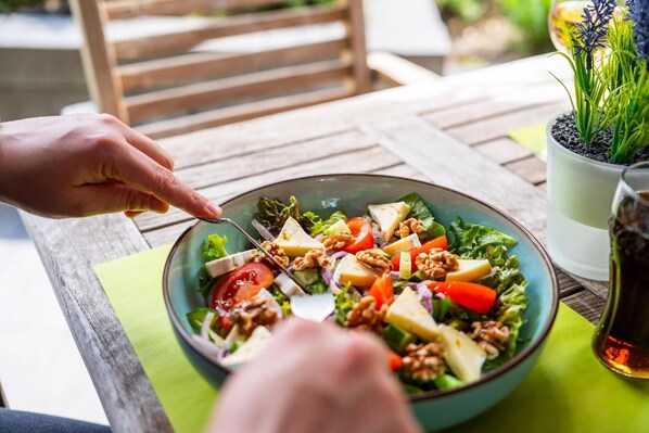 A person eating a salad with a fork.