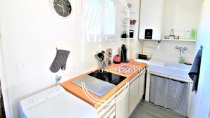 A modern kitchen with a built-in oven, a coffee machine, and a sink.