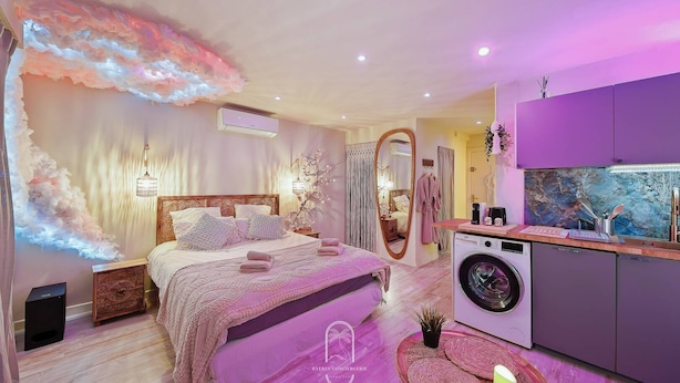 Ein Schlafzimmer mit einem Bett, einer Waschmaschine und einem Spiegel.