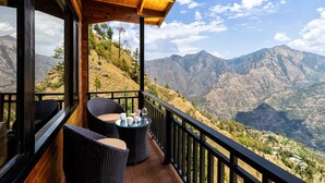 A wooden deck with wicker furniture overlooking a mountainous landscape. -  juSTa Cliffend Resort & Spa Mashobra Shimla (Shimla)