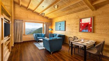 Luxe studio suite, 1 kingsize bed, balkon, uitzicht op bergen | Woonruimte | Een 42-inch ledtelevisie met kabelzenders en boeken