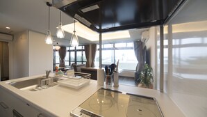 Een moderne keuken met een ingebouwde kookplaat, een spoelbak en hangende lampen.