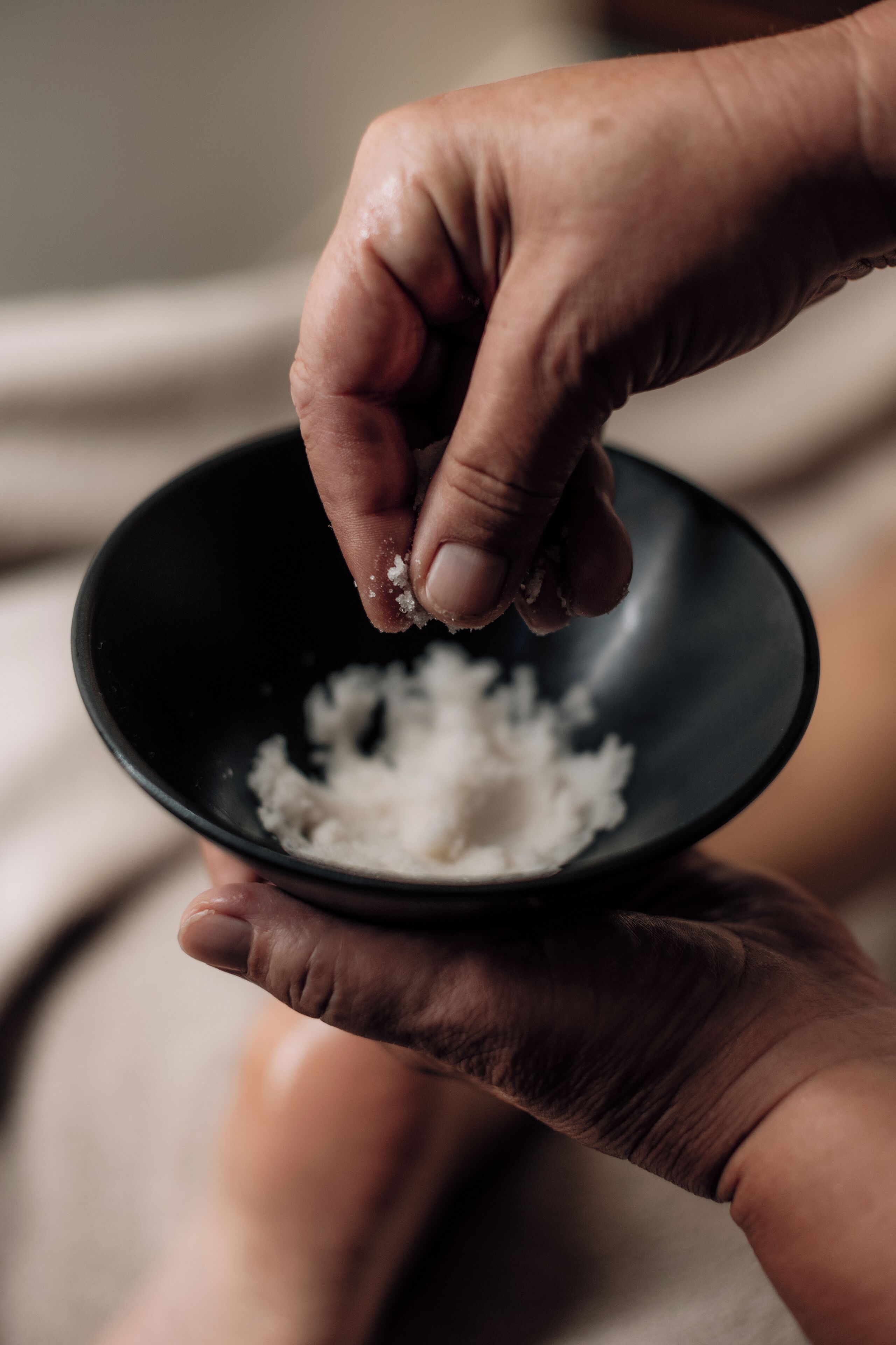 A close-up of hands holding a bowl with rice.