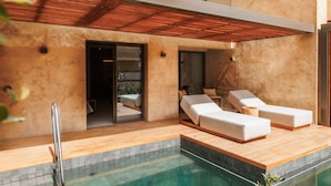 A modern outdoor pool area with a wooden deck, two white lounge chairs, and a glass door leading to a covered patio. - M Boutique Hotel - Designed for Adults (Paphos)