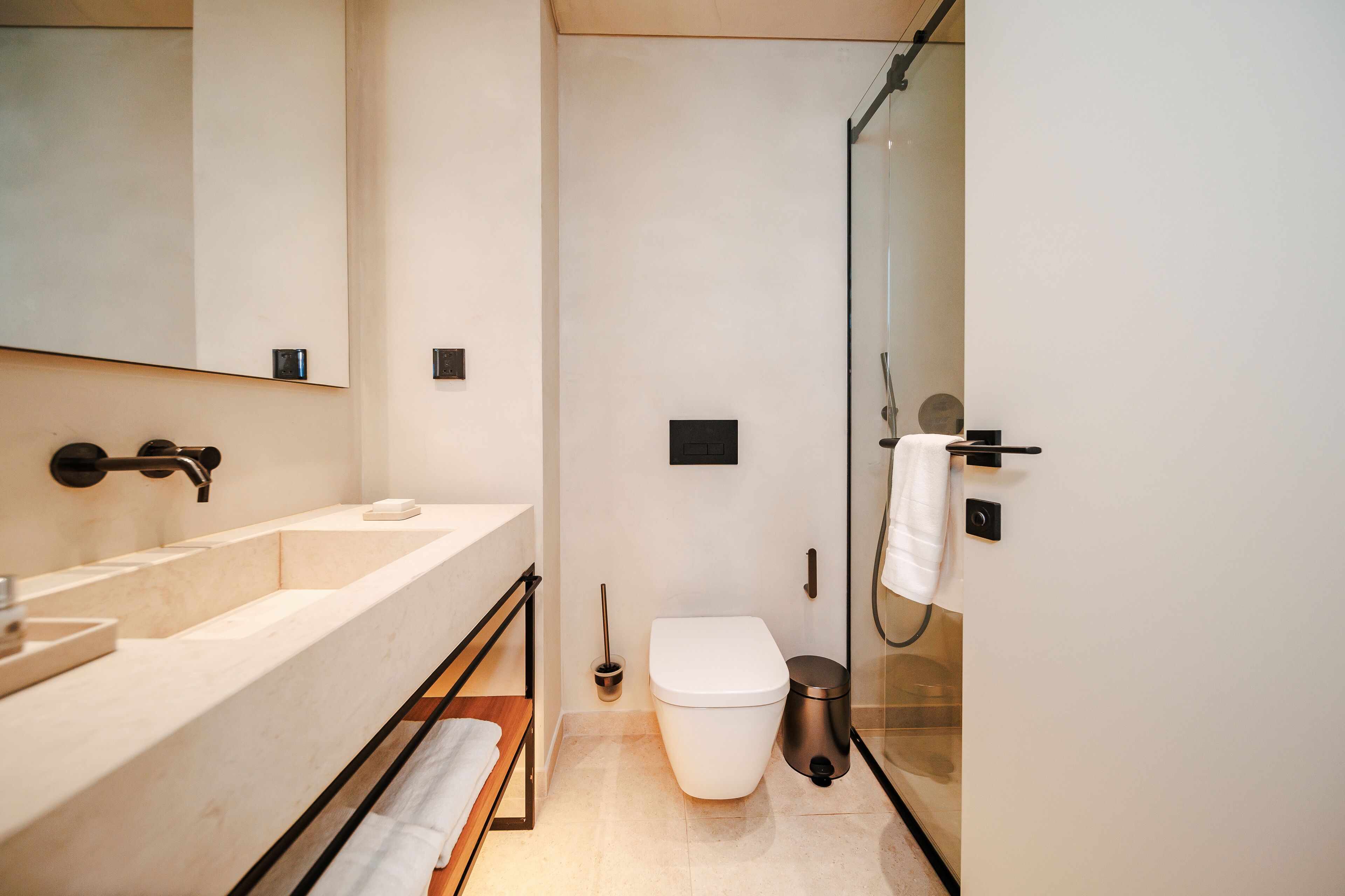 A modern bathroom with a bathtub, toilet, and shower.