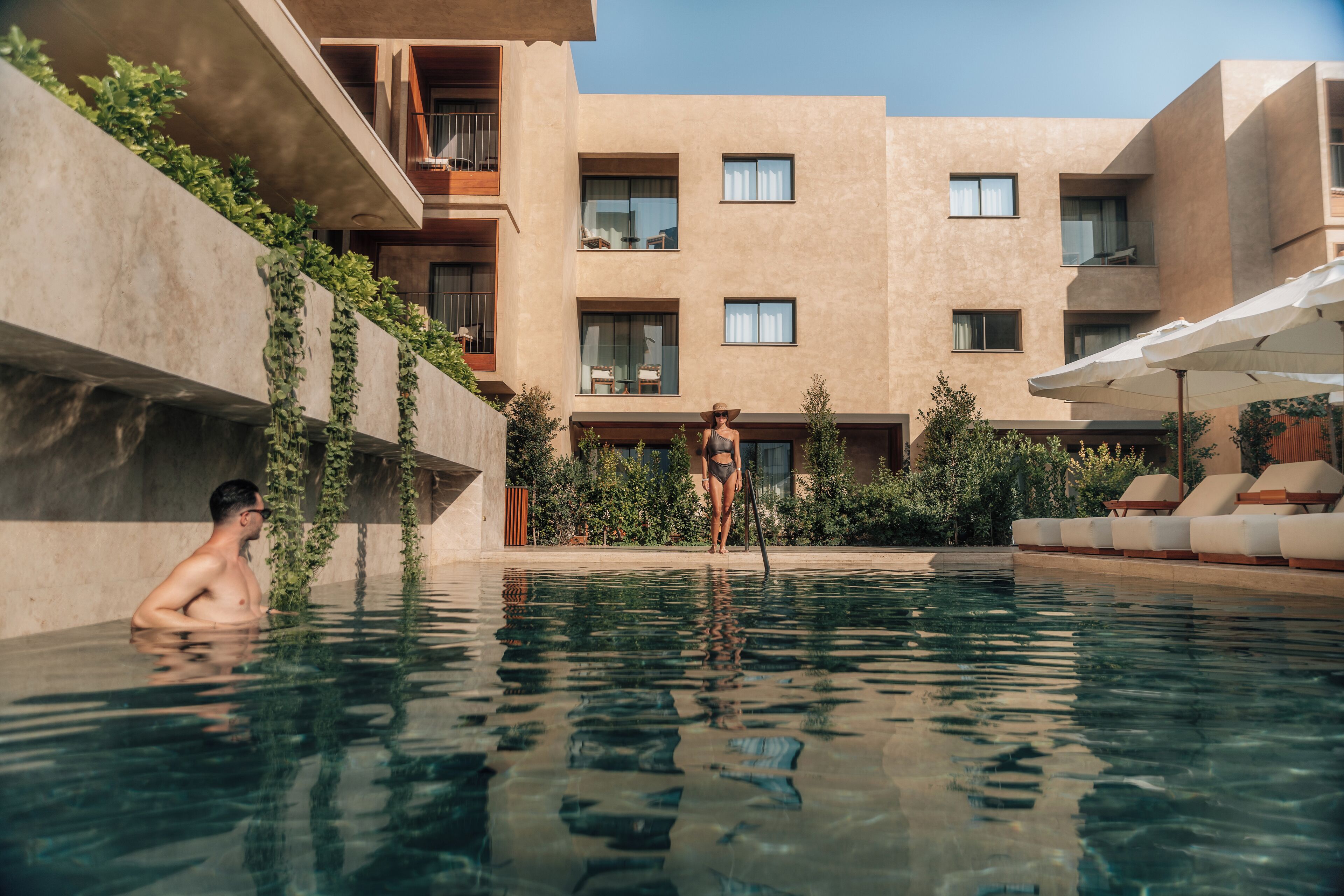 A man in a swimming pool with a building in the background.