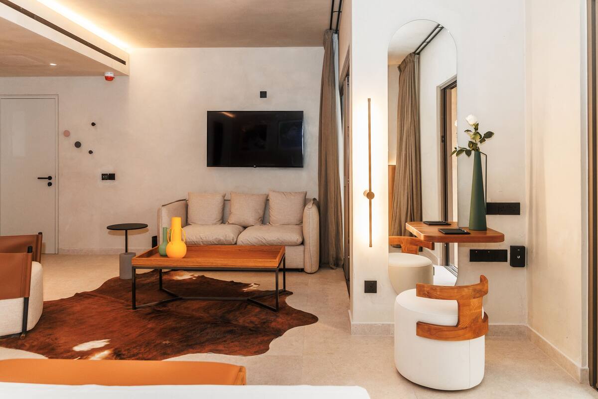 A modern living room with a sofa, coffee table, and a flat-screen TV mounted on the wall.