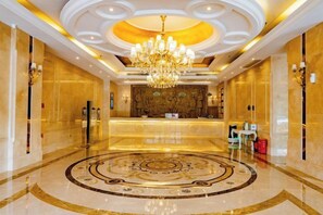 A hotel lobby with a central reception desk, a chandelier, and a circular patterned floor. - Vienna International Hotel (Liupanshui Shuicheng) (Liupanshui)