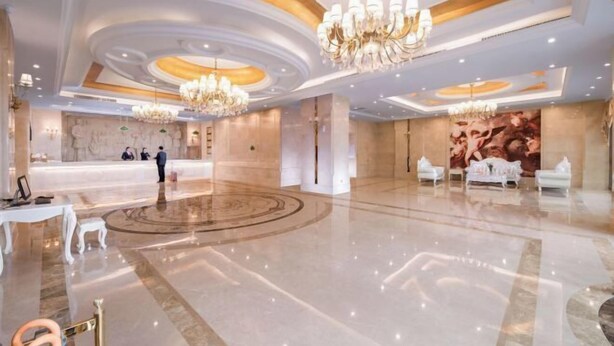 A spacious lobby with a polished marble floor, a reception desk, and elegant chandeliers. - Vienna International Hotel (Liupanshui Shuicheng) (Liupanshui)