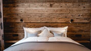 Una cama con cabecera de madera, una mesita de noche y una pared con diseño de paneles de madera.