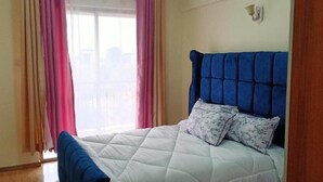 Une chambre à coucher avec un lit, des rideaux et une fenêtre.