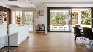 Una cocina moderna con un refrigerador blanco, armarios de madera y una zona de comedor con una mesa y sillas.