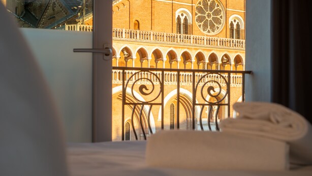 A hotel room with a view of a building with arches and a large window. - Padova Suites C20 (Padova)