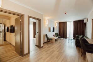 Habitación de lujo | Área de sala de estar | Smart TV de 130 cm con canales por cable y televisión 