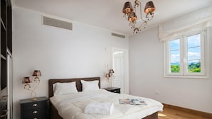 A bedroom with a bed, nightstands, lamps, a window, and a door. - Amazing Pool Villa Kyllini Sea View (Andravida-Kyllini)
