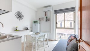 Un espace de vie compact comprenant un coin cuisine, un coin repas et un canapé avec vue sur la ville.