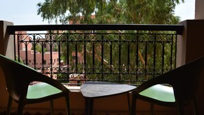 A balcony with a wrought iron railing, two chairs, and a view of buildings and trees. - Appart Chic EL Pacha hypercentre Gueliz station (Marrakech)