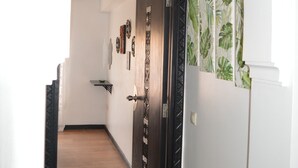 A hallway with a wooden floor, white walls, and a black door with a decorative pattern. - Appart Chic EL Pacha hypercentre Gueliz station (Marrakech)