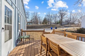 A wooden deck with a table and chairs, overlooking a residential area with houses and bare trees. - Boho Lounge - Pet Friendly Home Close to I-35 & KC (Merriam)