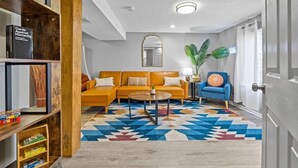 Ein Wohnzimmer mit einer Couch, einem Couchtisch und einem gemusterten Teppich.