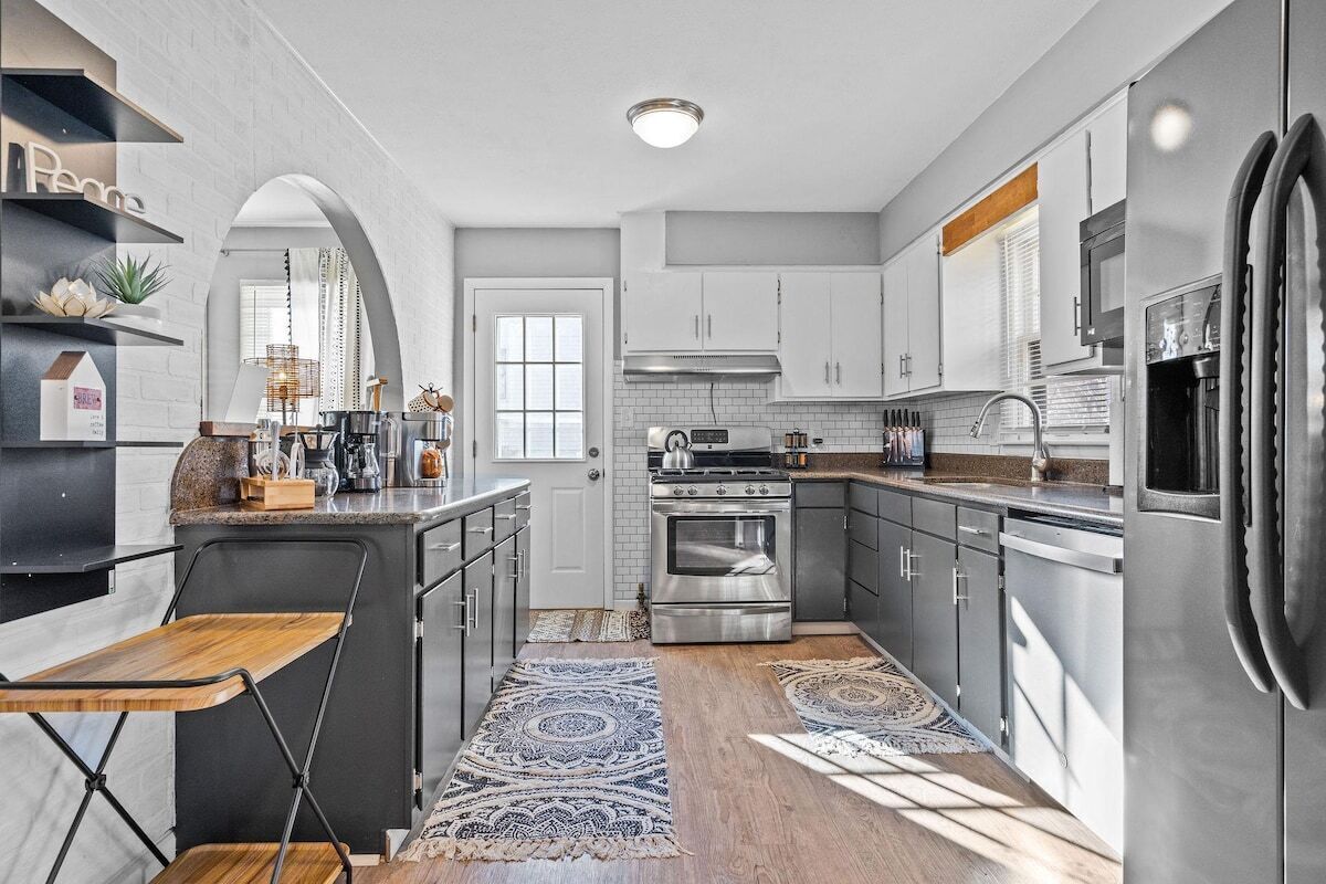 A modern kitchen with a central island, stainless steel appliances, and a view to the dining area.
