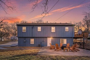 A two-story house with a front porch and outdoor seating area. - Boho Lounge - Pet Friendly Home Close to I-35 & KC (Merriam)
