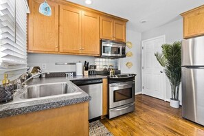 Una cocina moderna con armarios de madera, electrodomésticos de acero inoxidable y encimera de granito.