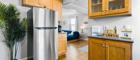 Une cuisine moderne avec des meubles en bois, un réfrigérateur en acier inoxydable et une plante en pot.