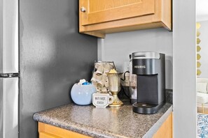 A kitchen counter with a coffee maker, a decorative vase, and a mug with text. - Kansas City Townhouse Walk to Plaza+Streetcar 1006 (Kansas City)