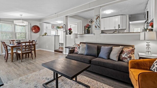 A modern living room with a sofa, coffee table, and dining area.