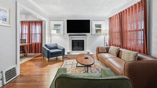 A living room with a fireplace, a television, and a sofa. - Plaza Perch -Walk to Plaza & Westport! (Kansas City)