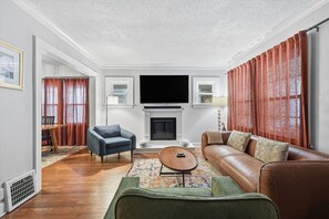A living room with a fireplace, a television, and a sofa.