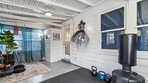 A room with a large window, a punching bag, kettlebells, and a plant. - Plaza Perch -Walk to Plaza & Westport! (Kansas City)