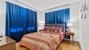 A bedroom with a large bed, two bedside lamps, a nightstand, and a dresser. - Plaza Perch -Walk to Plaza & Westport! (Kansas City)
