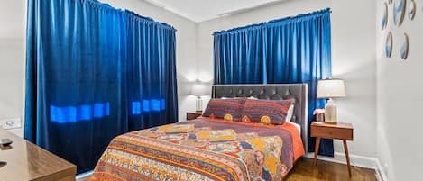 Un dormitorio con una cama grande, dos lámparas de noche, una mesita de noche y un aparador.