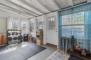 A room with a ceiling fan, a window with curtains, a door, and a small statue on a shelf. - Plaza Perch -Walk to Plaza & Westport! (Kansas City)