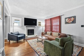 A living room with a fireplace, a television, a sofa, and a coffee table.