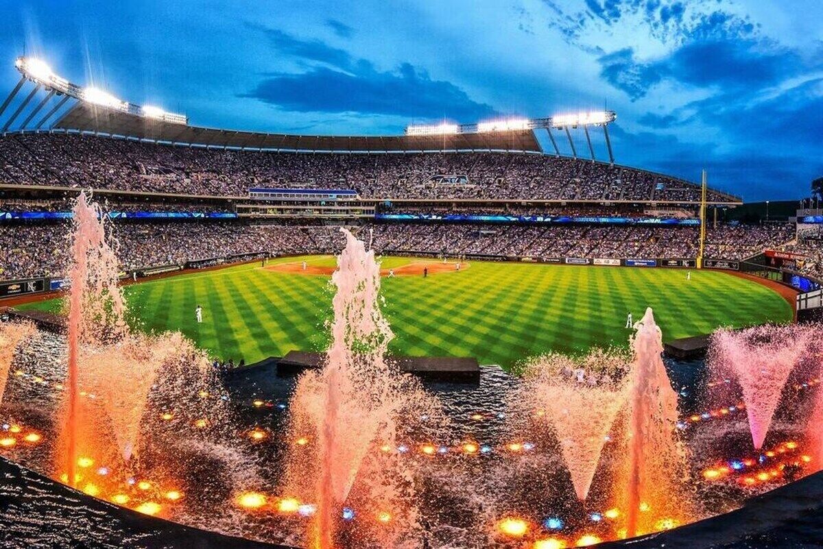 A stadium with multiple tiers of seating and a central field.