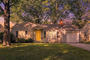 A single-story house with a garage, a front door, and a mailbox.