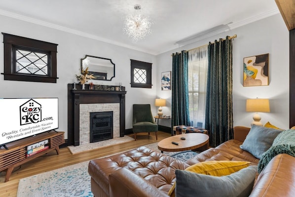 A living room with a fireplace, leather sofa, and a coffee table.