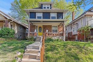 A two-story house with a front porch, a visible number '820' on the front, and a staircase leading to the entrance.