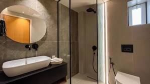 Une salle de bain moderne avec une baignoire sur pieds, un grand miroir et une douche séparée par des parois en verre.