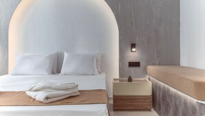 Une chambre à coucher moderne avec un grand lit, une table de chevet avec une lampe et un banc.