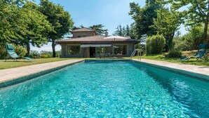 Una piscina con un edificio de piedra al fondo.