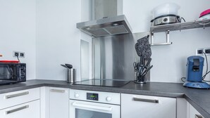 A modern kitchen with stainless steel appliances, a built-in oven, and a coffee machine.