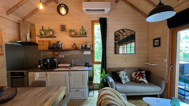 A cozy cabin interior with a kitchen, dining area, and living room.