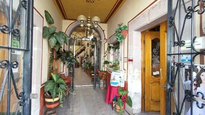 A hallway with potted plants, a staircase, and a wooden door. - OYO Posada Santa Cecilia, Jerez Zacatecas  (Jerez de Garcia Salinas)