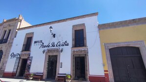 A building with a sign for Hotel El Poroda Sta. Cecilia, featuring a traditional facade with ornate details, a large entrance door, and a small balcony. - OYO Posada Santa Cecilia, Jerez Zacatecas  (Jerez de Garcia Salinas)