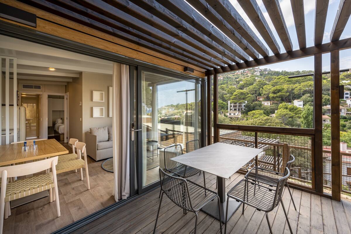 Un espace de restauration extérieur moderne, doté d’une terrasse en bois, d’une table et de chaises.