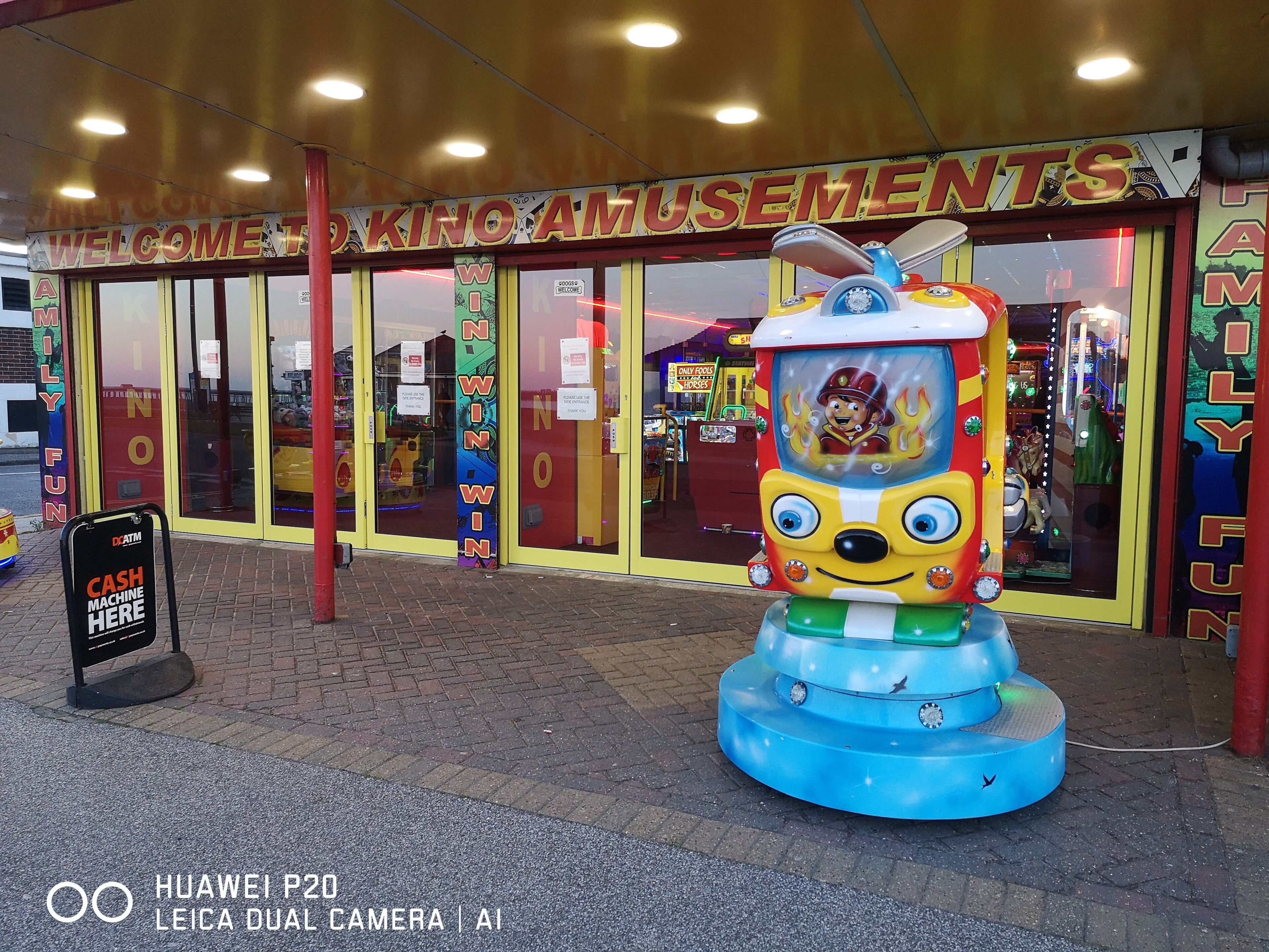 An arcade entrance with a large, colorful game machine in front.
